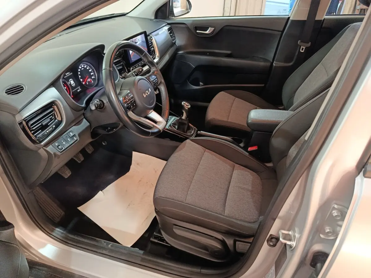 Vue intérieure côté conducteur du Kia Stonic gris clair 2022, avec tableau de bord numérique et volant multifonctions.