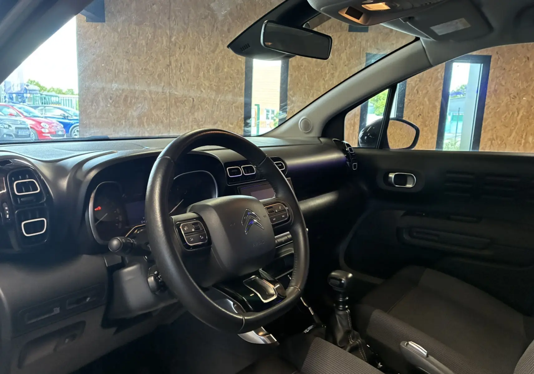 Intérieur côté conducteur du Citroën C3 Aircross gris platinium, volant cuir multifonction et tableau de bord moderne.