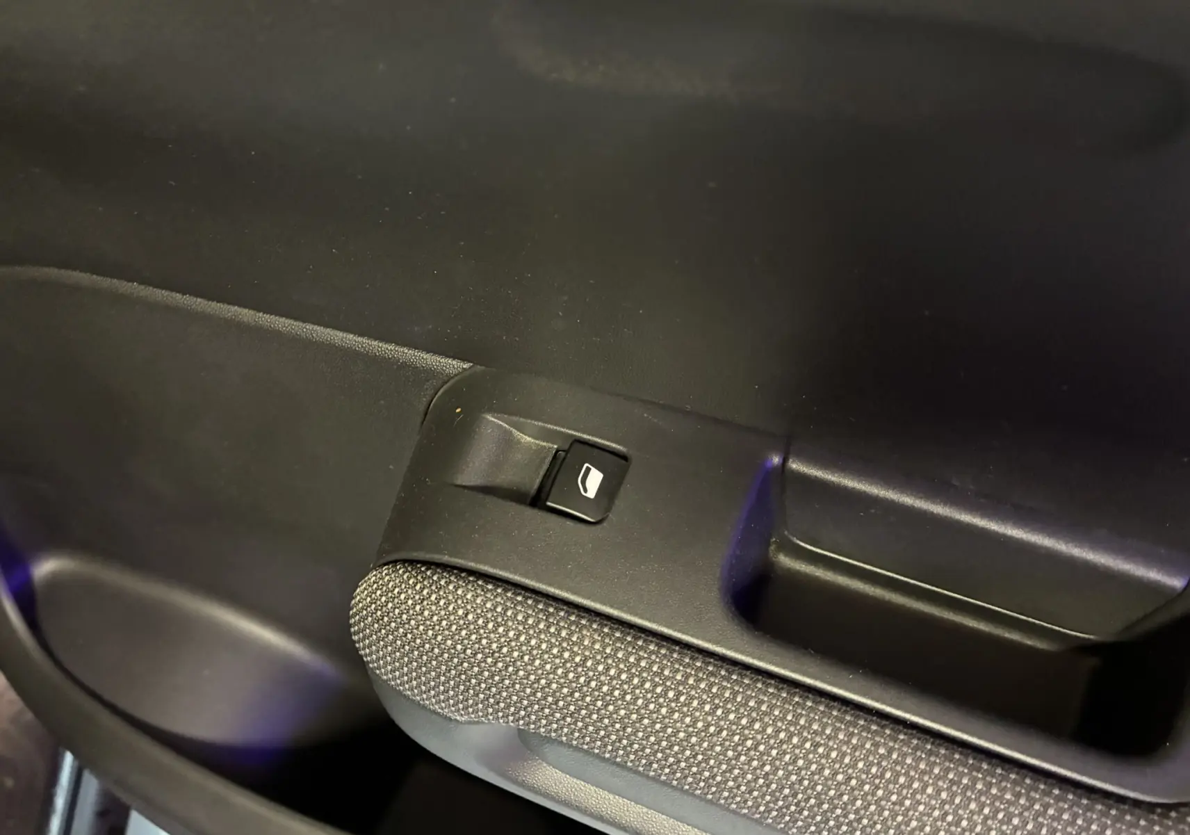 Gros plan sur le bouton de commande de la vitre électrique côté intérieur d'une Citroën C3 Aircross 2023 finition Shine.