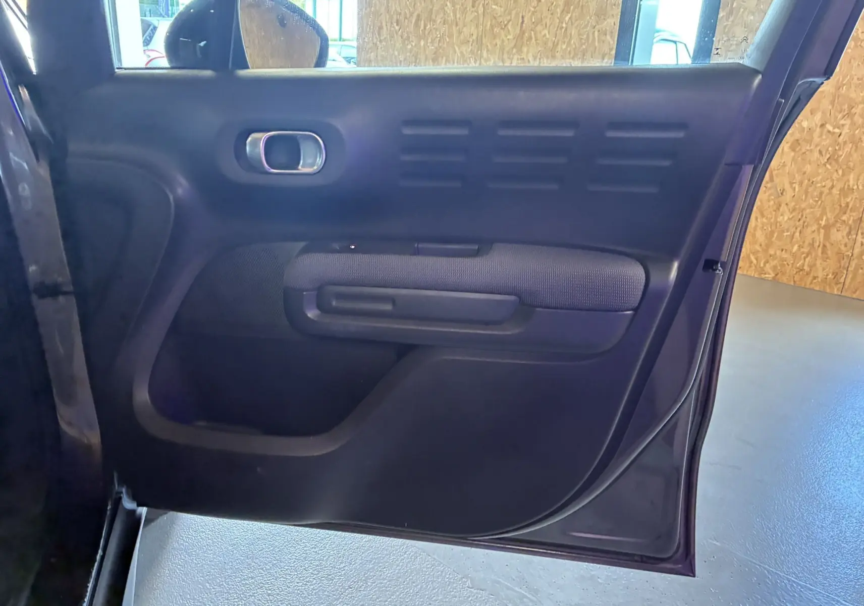 Porte arrière gauche ouverte du Citroën C3 Aircross 1.5 BlueHDi 110 Shine, intérieur noir avec tissu gris.