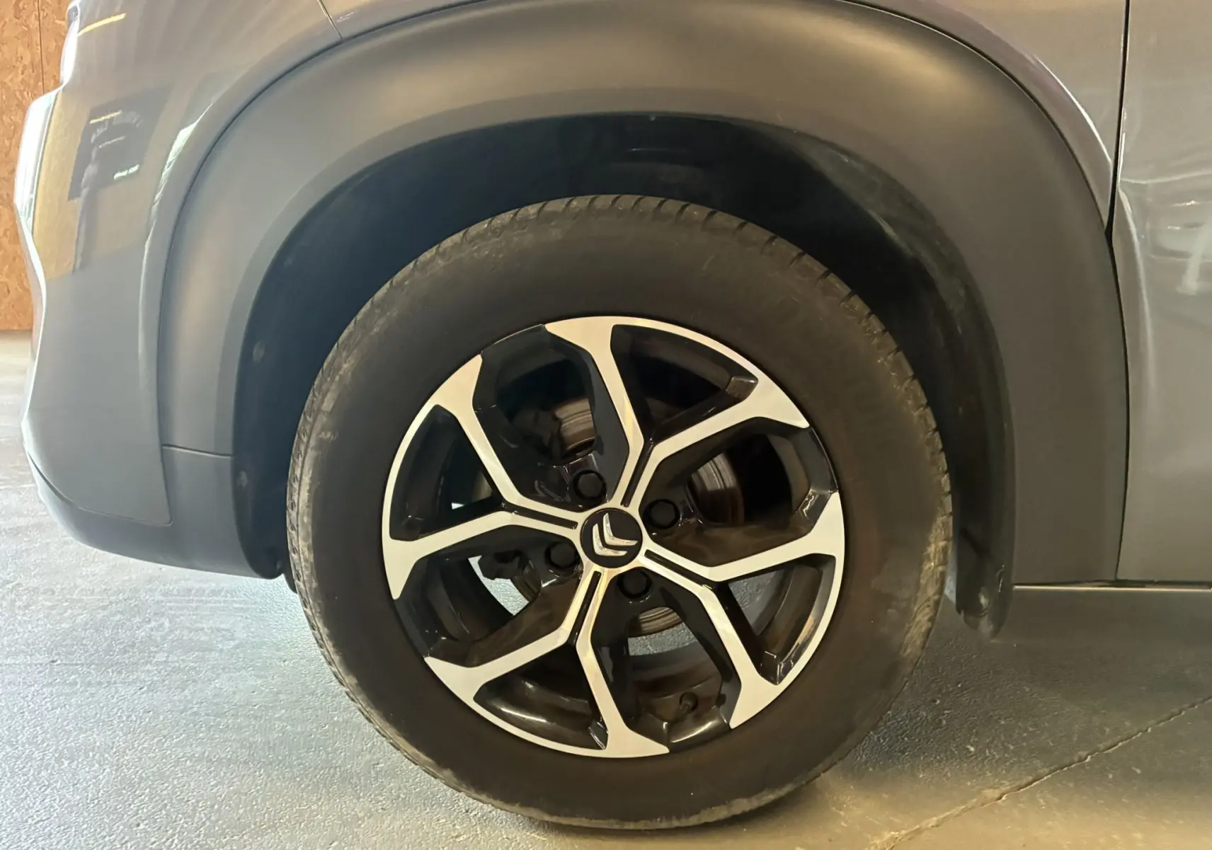 Gros plan sur la roue avant gauche du Citroën C3 Aircross gris platinium avec jante alu bi-ton 16 pouces.