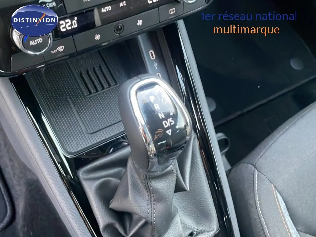 Le levier de vitesses automatique noir brillant du Skoda Kamiq gris argent, vu en gros plan depuis l'intérieur.