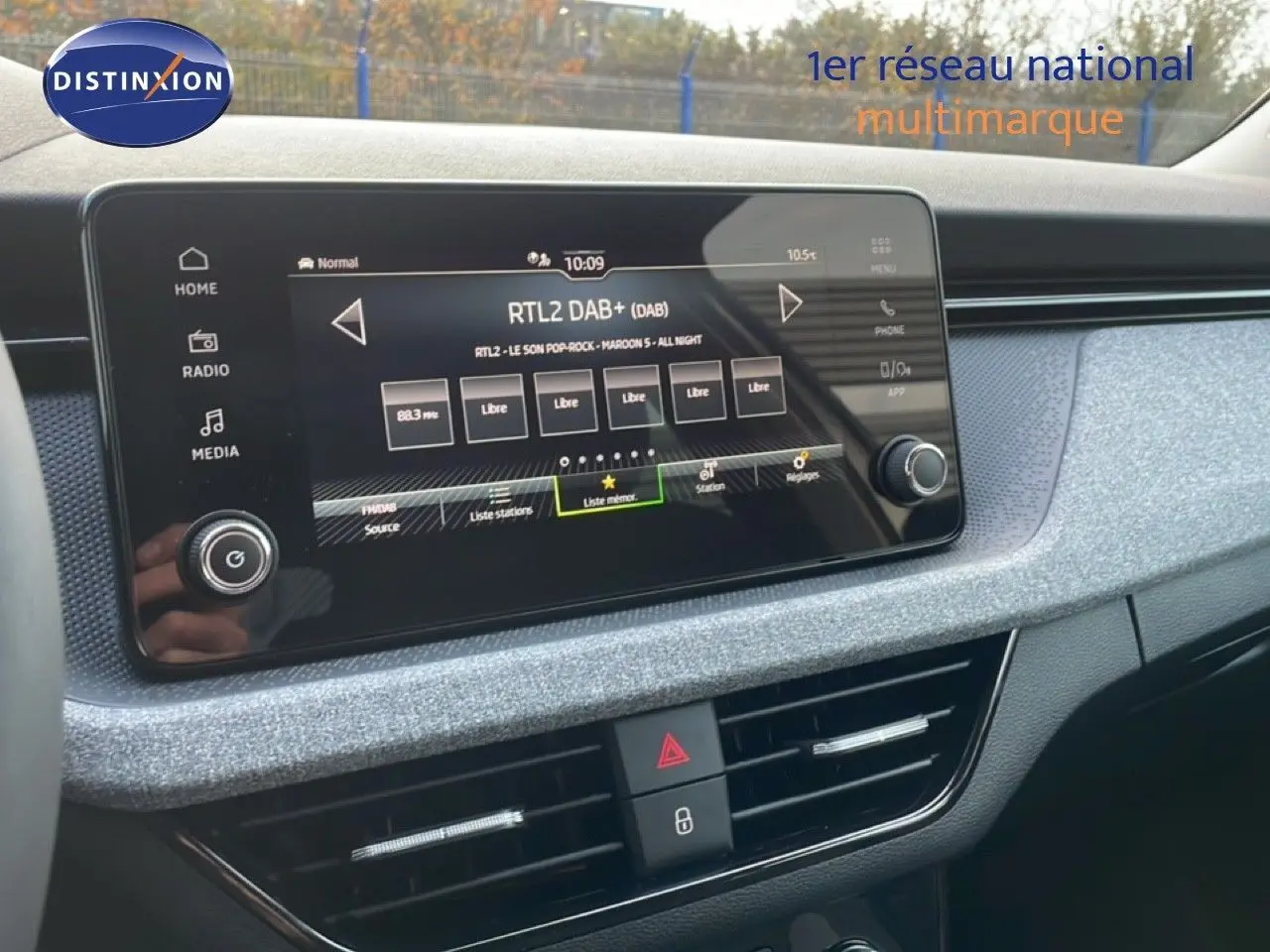 Vue intérieure centrée sur l'écran tactile multimédia du Skoda Kamiq gris argent avec finition tissu gris.