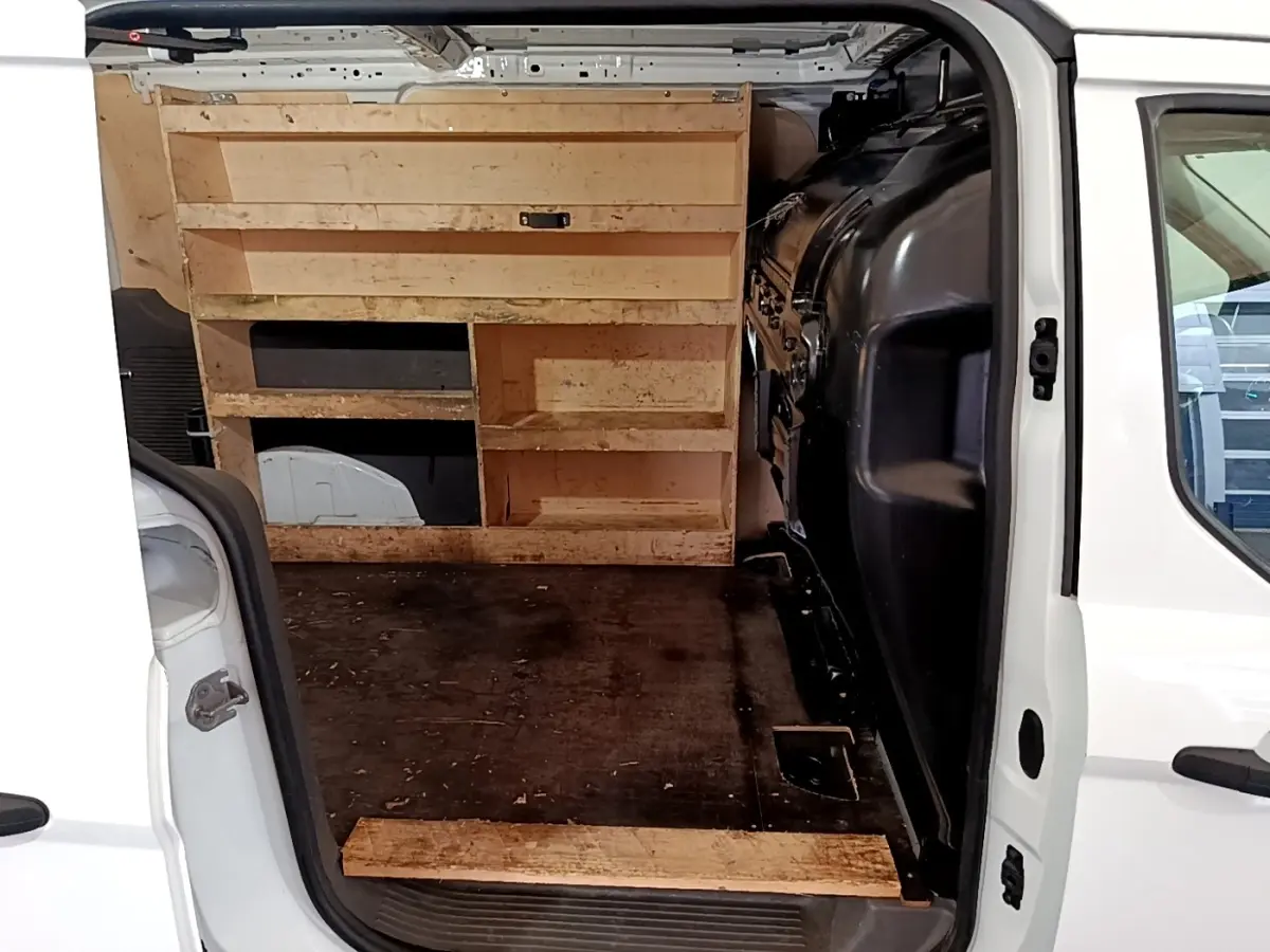 Vue intérieure arrière du Ford Transit Fourgon blanc 2022, montrant l’espace de chargement avec étagères en bois.