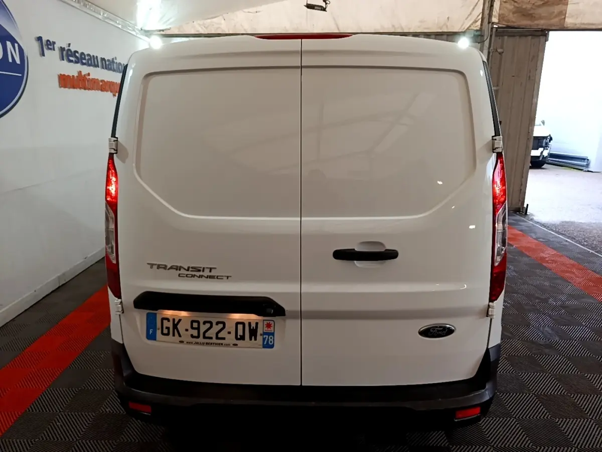 Vue arrière du fourgon blanc Ford Transit Connect 2022 avec portes battantes et feux arrière allumés.