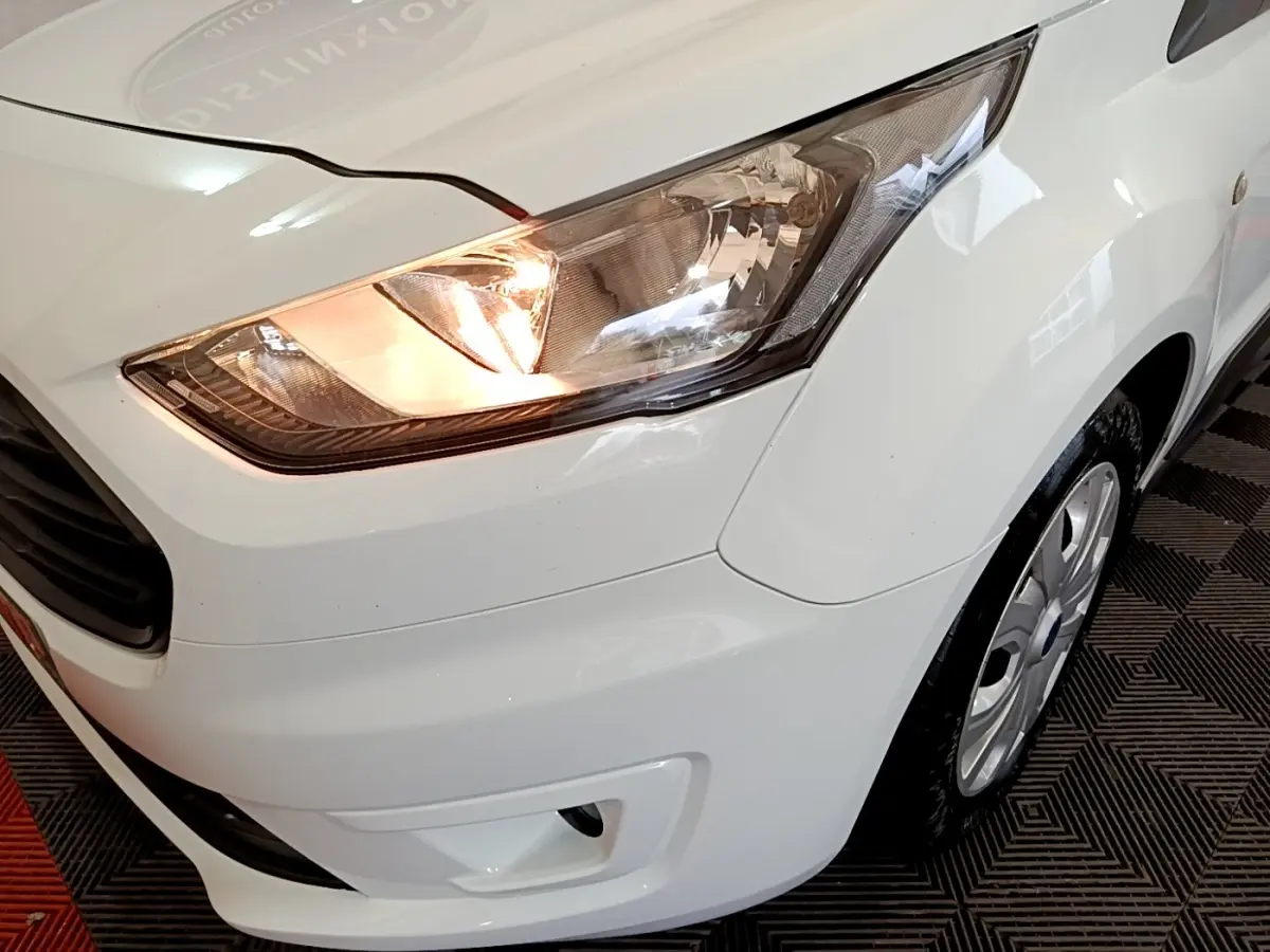 Gros plan sur l'avant droit blanc du Ford Transit Fourgon 2022 avec phare allumé et jante visible.