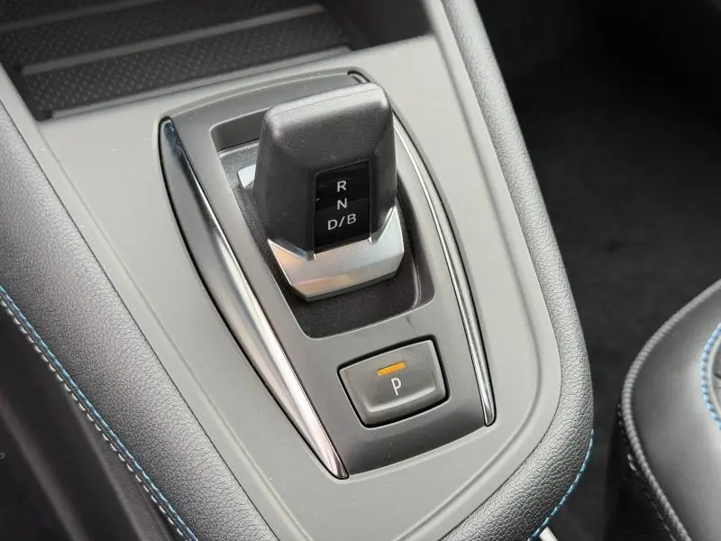 Gros plan sur la commande de boîte automatique du Renault Captur 2026, avec surpiqûres bleues et finition noire.