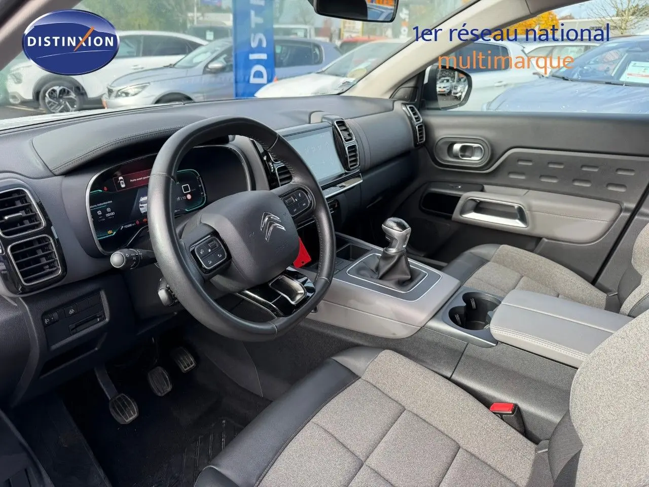 Intérieur du Citroën C5 Aircross 2019, vue côté conducteur, volant cuir, tableau de bord numérique et levier manuel.