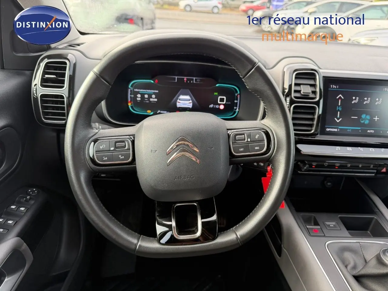 Vue frontale du volant en cuir noir et du tableau de bord numérique du Citroën C5 Aircross blanc nacré de 2019.