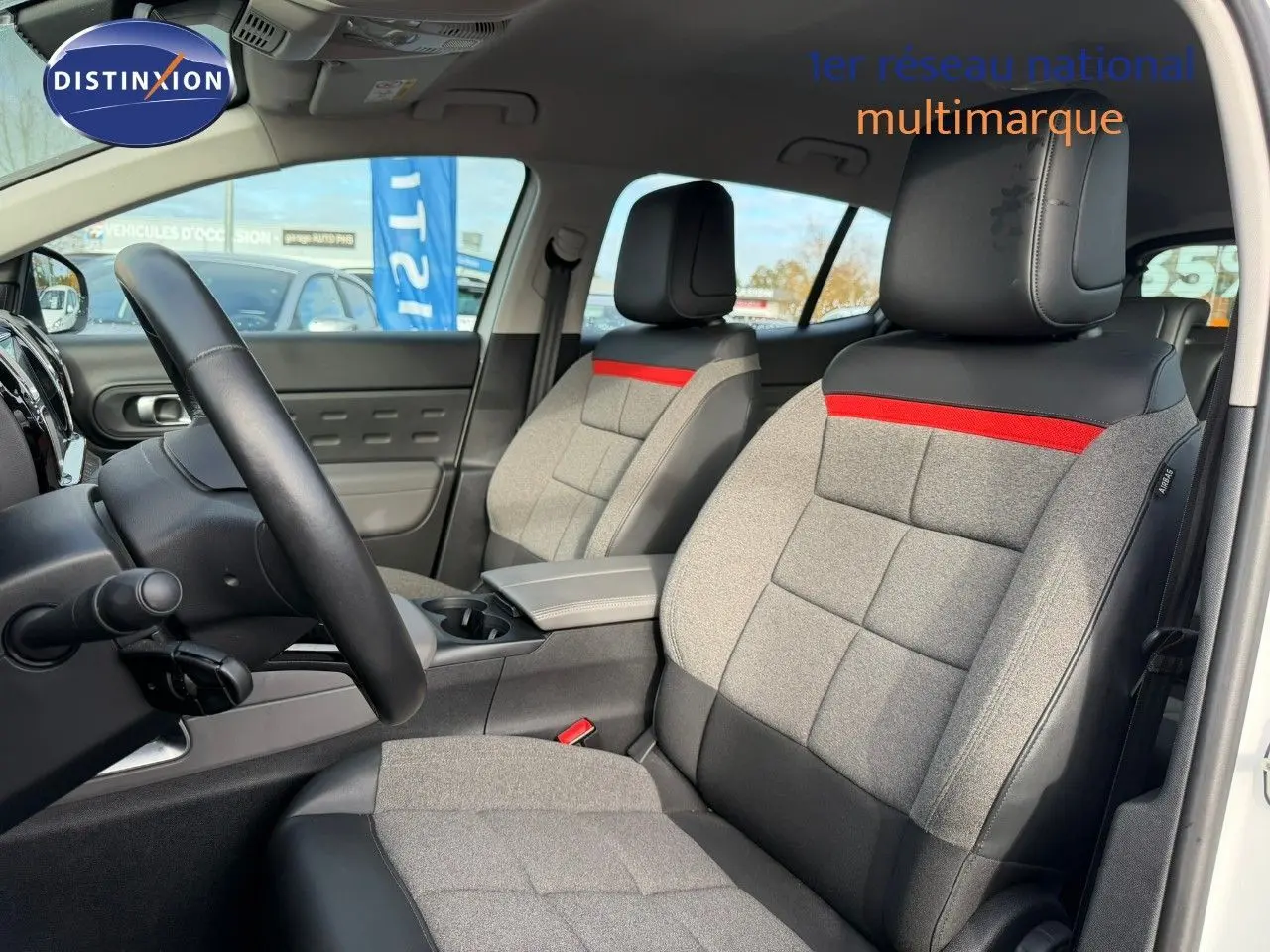 Vue intérieure côté conducteur du Citroën C5 Aircross blanc nacré, sièges gris avec bande rouge et cuir noir.