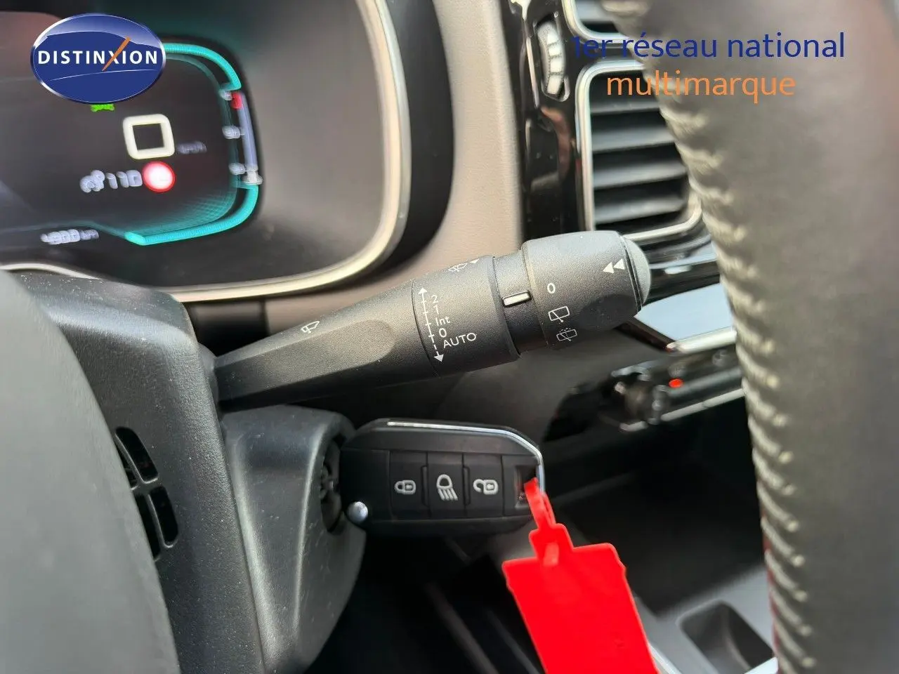 Gros plan sur la commande d'essuie-glace et la clé insérée dans le contacteur d'un Citroën C5 Aircross blanc nacré de 2019.