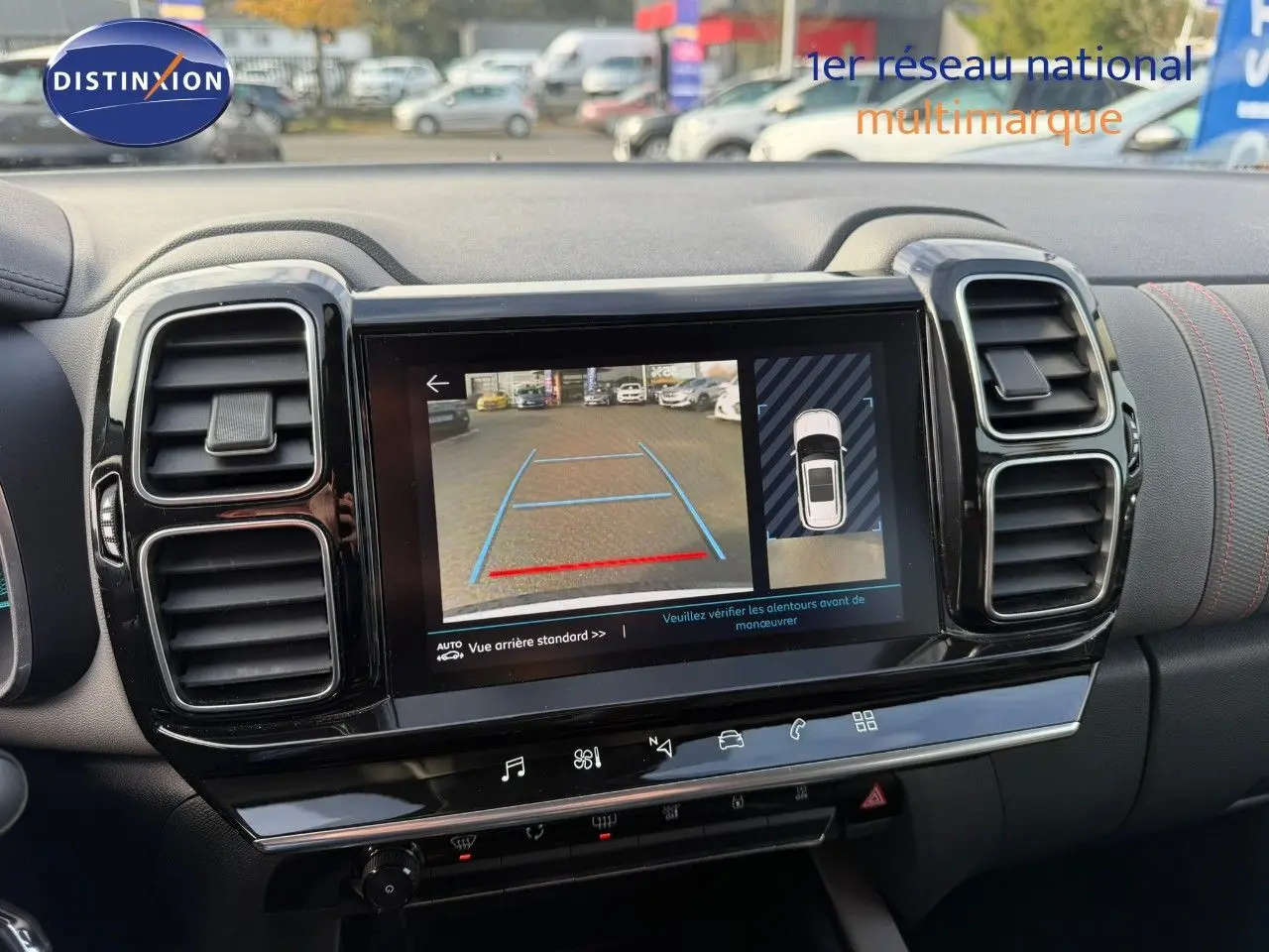 Vue rapprochée de l'écran multimédia affichant la caméra de recul dans l'habitacle noir du Citroën C5 Aircross blanc nacré.