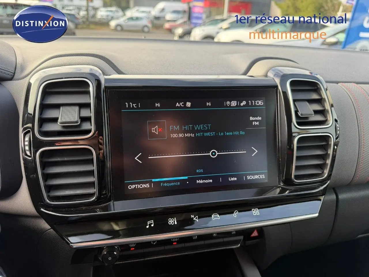 Écran tactile central allumé avec radio FM, entouré de deux aérateurs noirs sur tableau de bord gris du Citroën C5 Aircross.