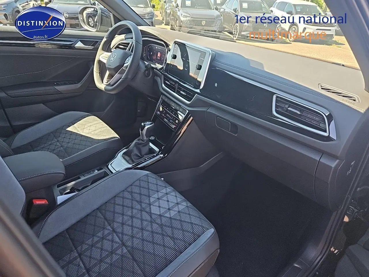Intérieur du Volkswagen T-Roc 2025 noir perle, vue côté passager avec sièges tissu r-line et tableau de bord moderne.