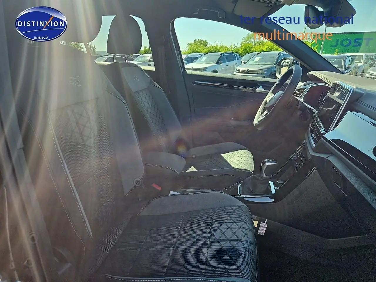 Intérieur avant du Volkswagen T-Roc 2025, sièges tissu noir r-line avec volant cuir multifonction sport visible.