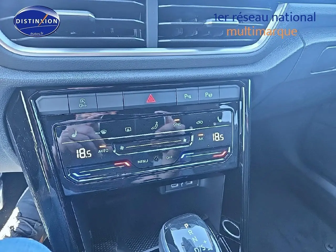 Vue rapprochée de la console centrale noire du Volkswagen T-Roc 2025 avec commandes clim et levier de boîte auto DSG7.