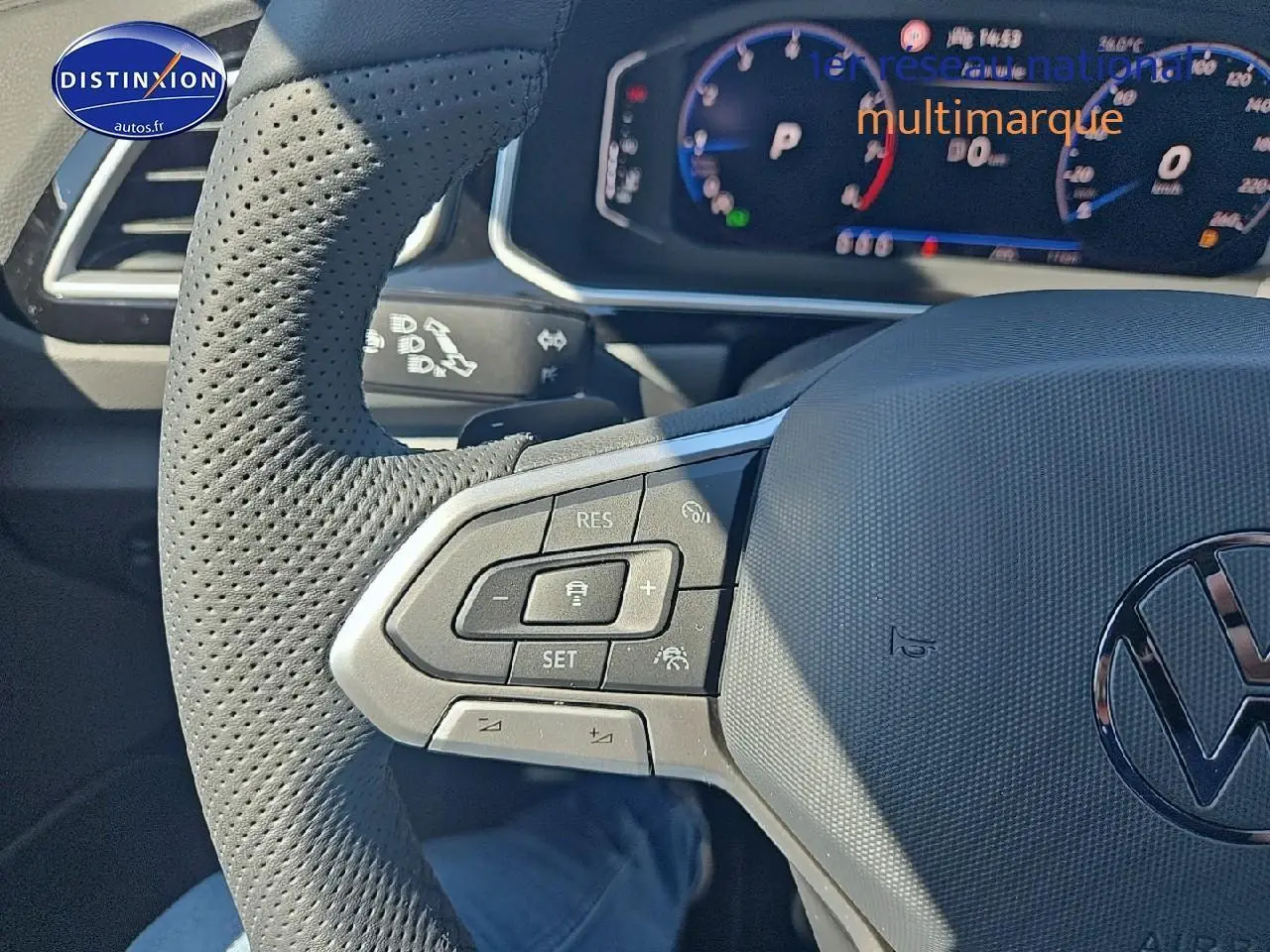 Gros plan sur le volant cuir perforé côté gauche du Volkswagen T-Roc noir perle avec commandes multifonctions et cockpit numérique.