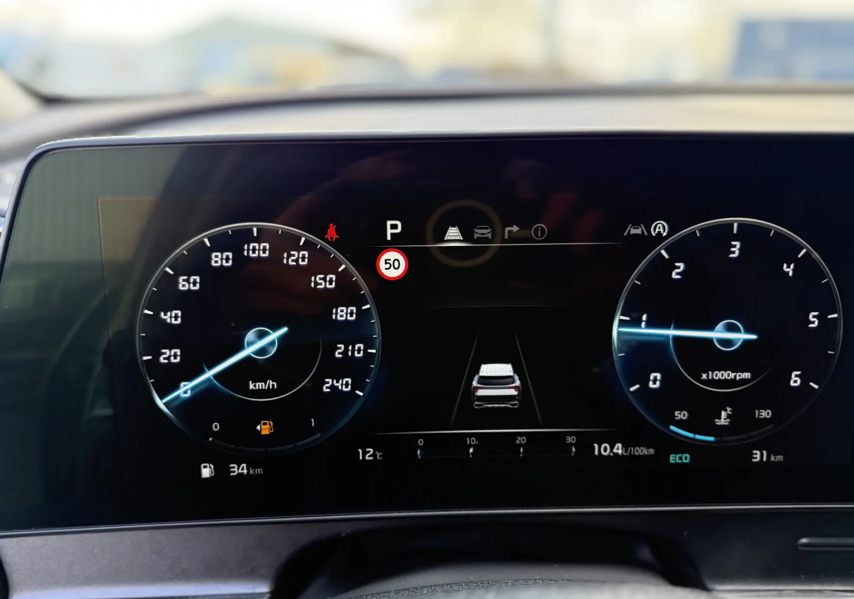 Vue intérieure côté conducteur du Kia Sportage 2025, sièges en tissu noir avec surpiqûres contrastantes.