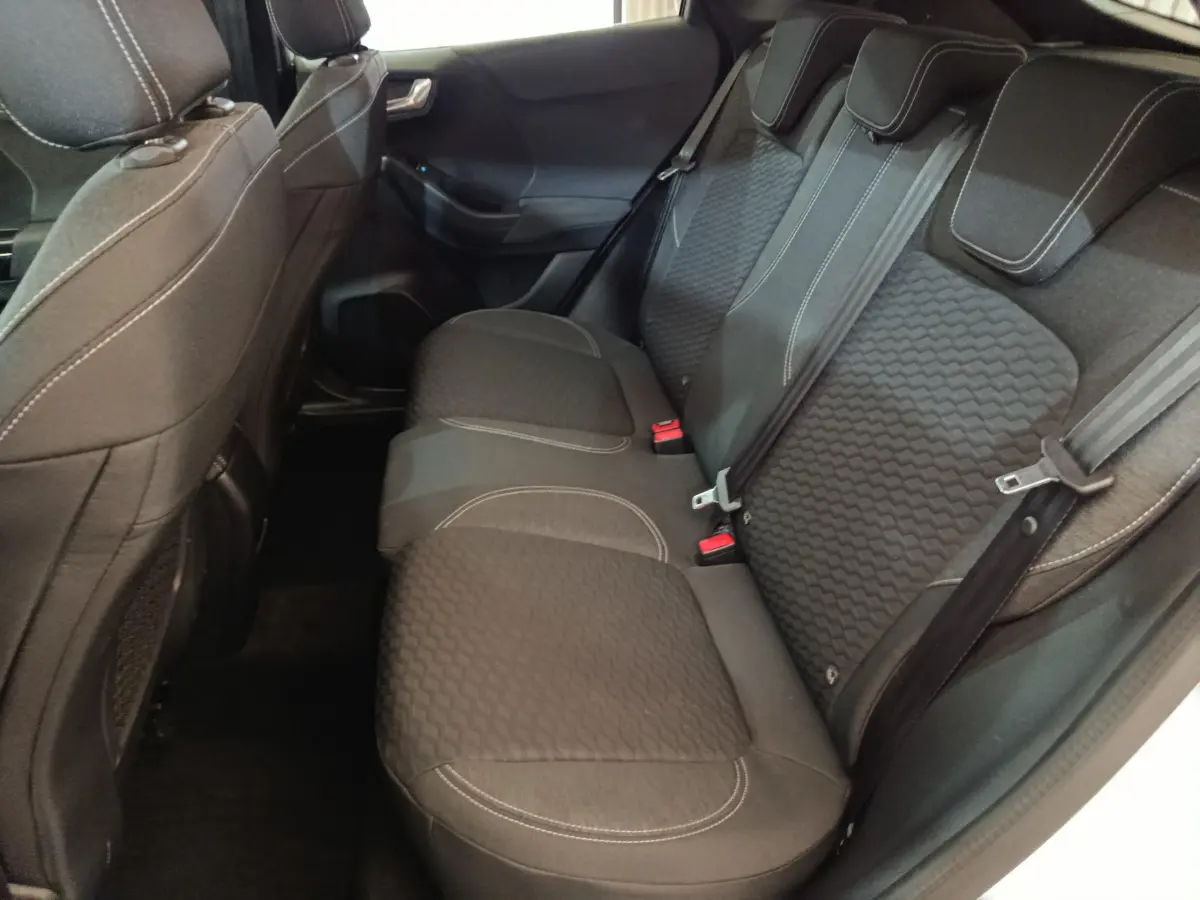 Vue intérieure côté droit des sièges arrière noirs avec surpiqûres blanches du Ford Puma 2022 blanc hybride.