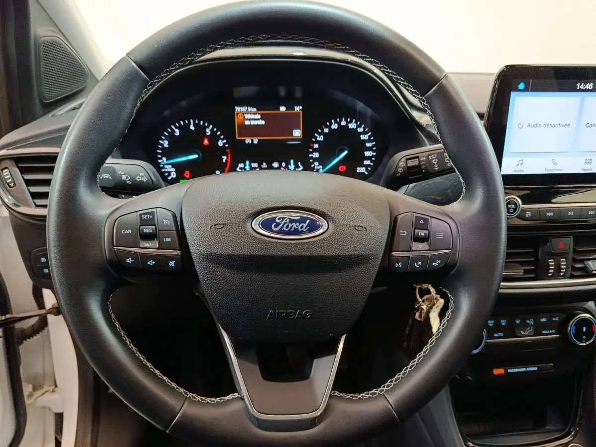 Vue centrée sur le volant cuir noir de la Ford Puma 2022 avec tableau de bord et écran tactile allumé.