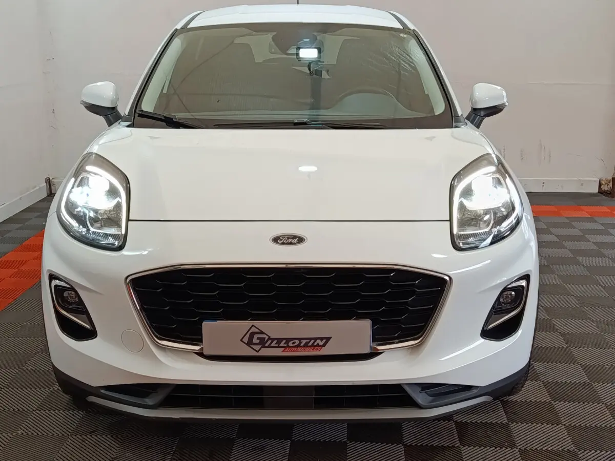 Vue frontale d'un Ford Puma blanc 2022 avec phares allumés et calandre noire distinctive.