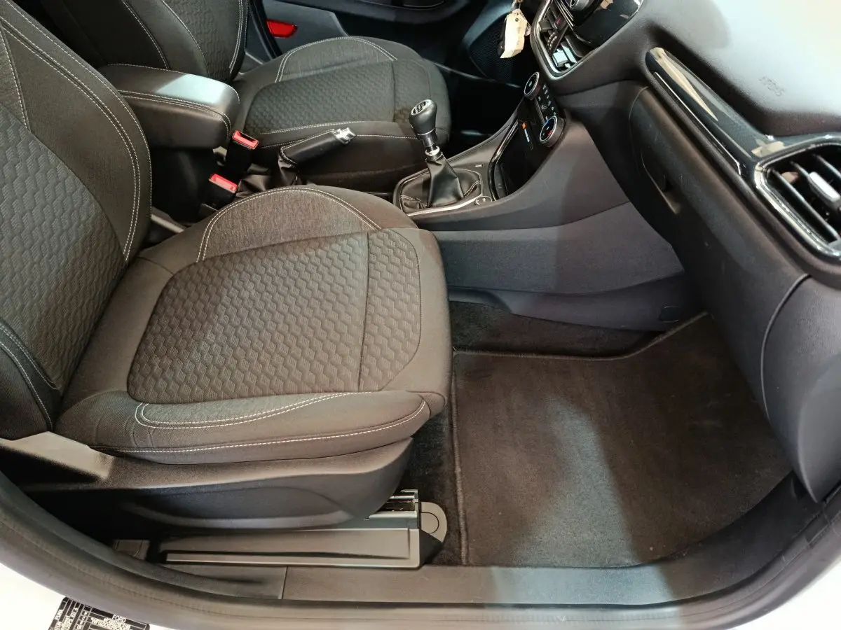 Vue intérieure côté passager avant du Ford Puma 2022, sièges noirs et console centrale avec levier de vitesses manuel.