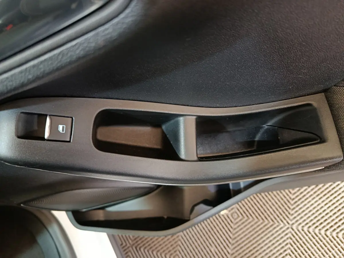 Poignée intérieure de porte côté gauche noire avec commande de lève-vitre sur Ford Puma blanc 2022.