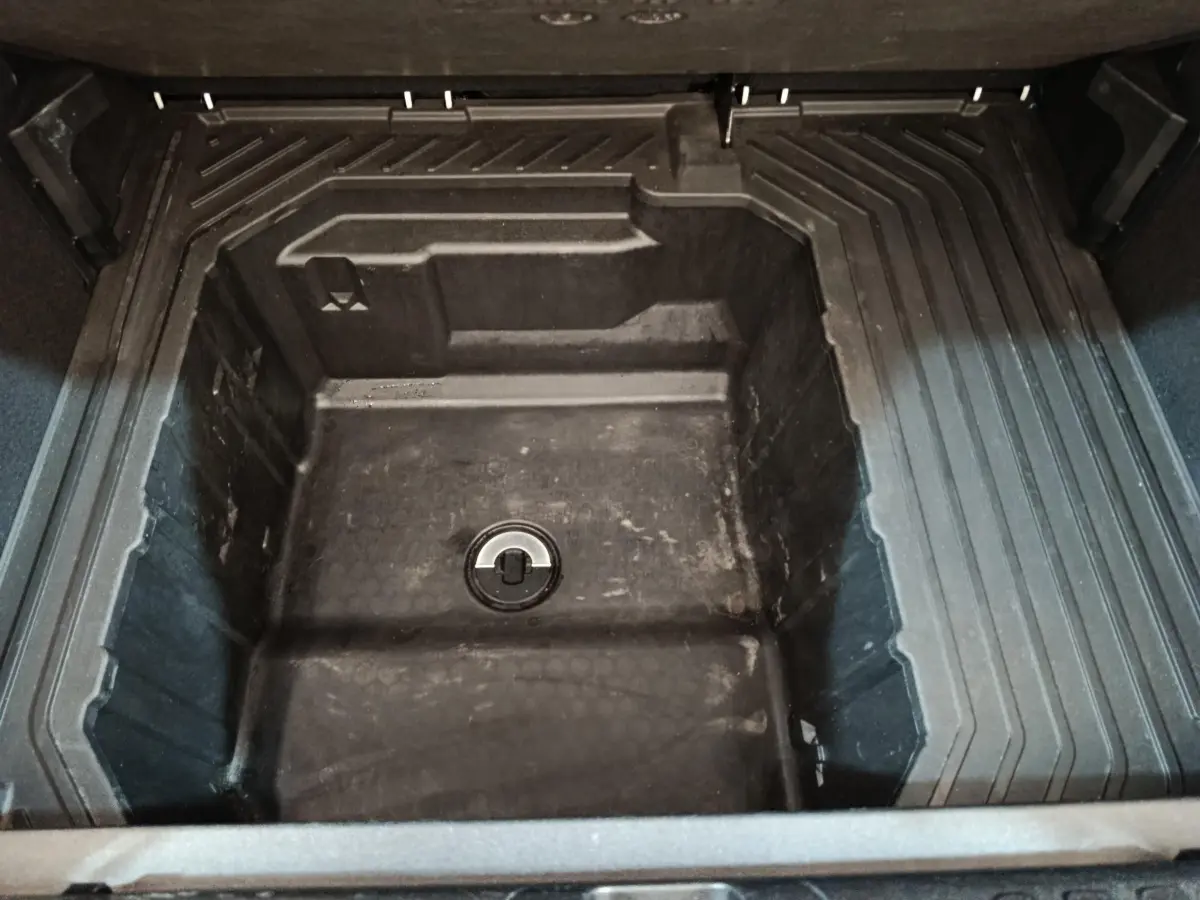 Vue rapprochée du coffre de la Ford Puma blanc 2022, montrant le compartiment de rangement sous la tablette.