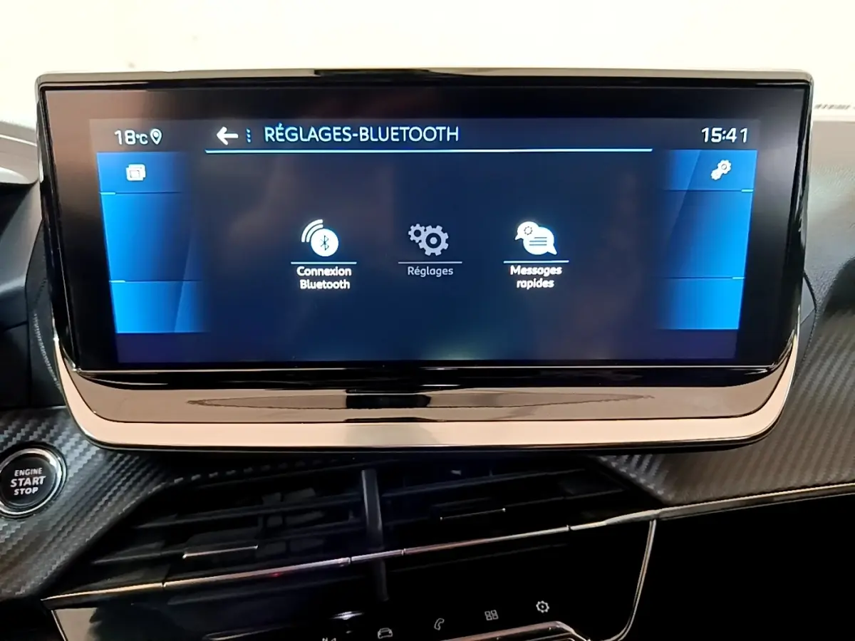 Écran tactile central affichant les réglages Bluetooth sur le tableau de bord carbone du Peugeot 2008 gris clair.