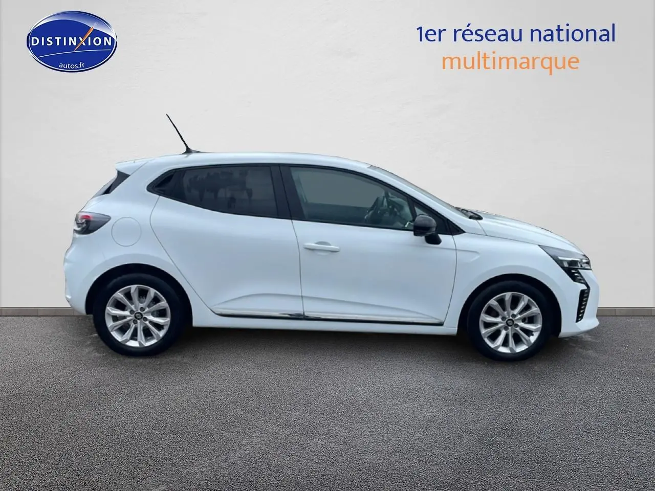 Profil droit d'une Renault Clio V blanche 2025 avec jantes alliage et vitres teintées sur fond neutre.