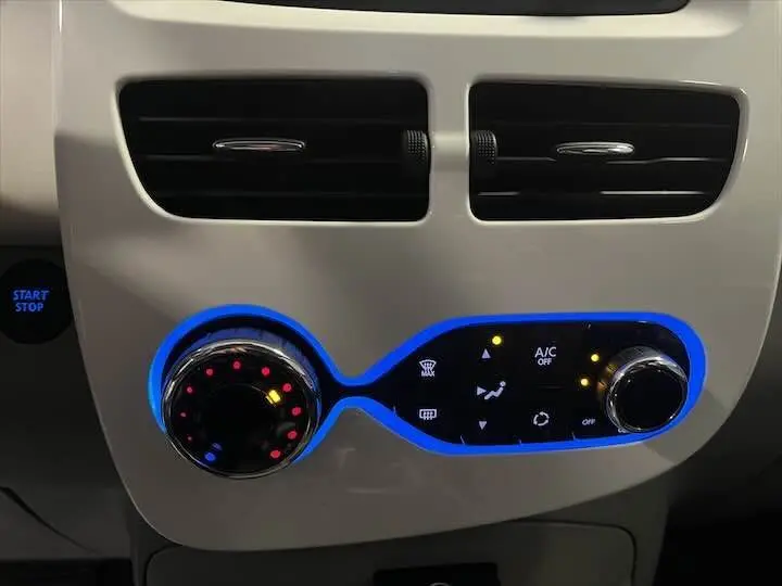 Gros plan sur la commande de climatisation avec éclairage bleu dans l’habitacle blanc glacier d’une Renault ZOE R90 LIFE 2019.