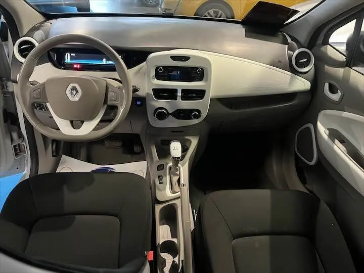 Intérieur de Renault ZOE blanc glacier, vue frontale du tableau de bord et volant avec commandes intégrées.