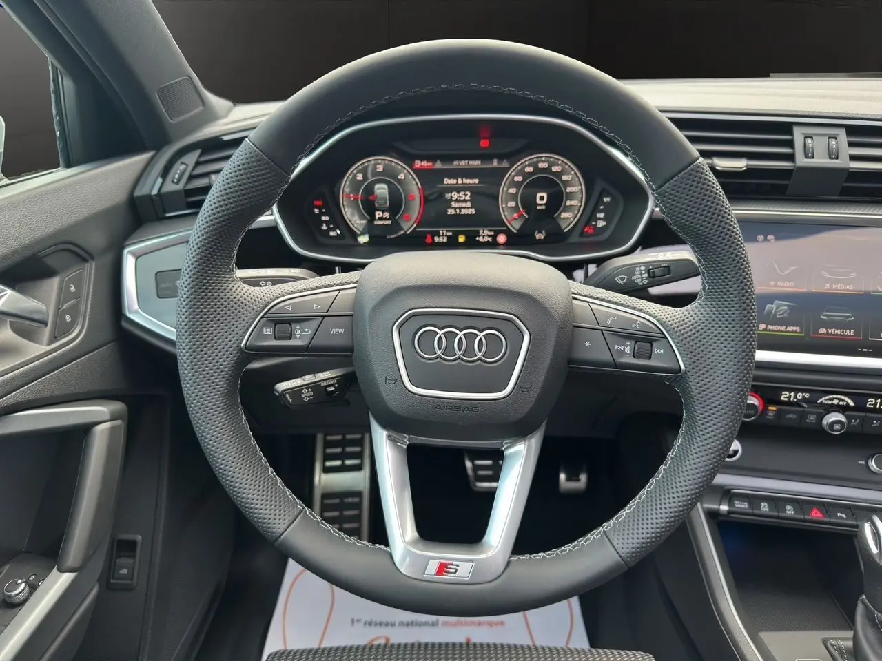 Volant sport S line en cuir perforé avec tableau de bord numérique et console centrale d'Audi Q3 Sportback 2024.