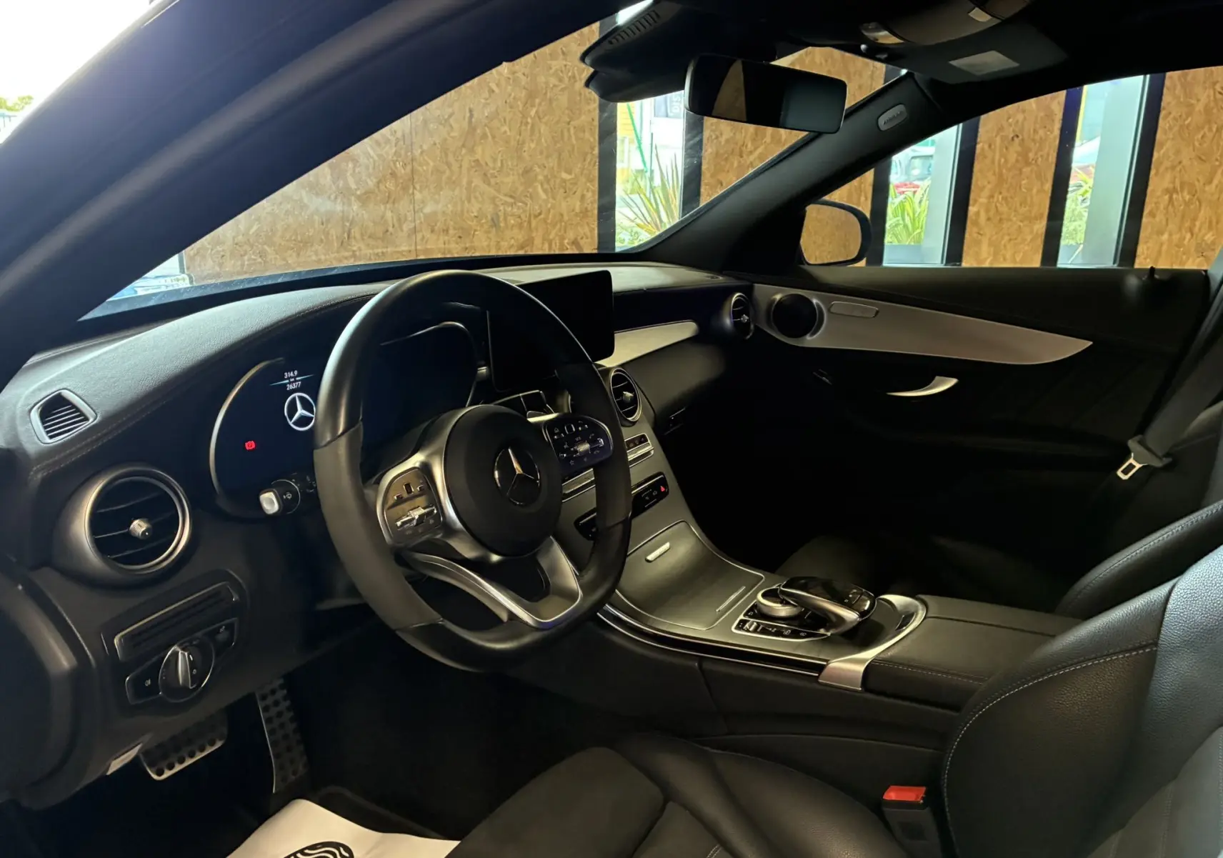 Intérieur noir de la Mercedes Classe C Break 220D AMG Line 2021, vue côté conducteur sur volant cuir multifonction et tableau de bord digital.