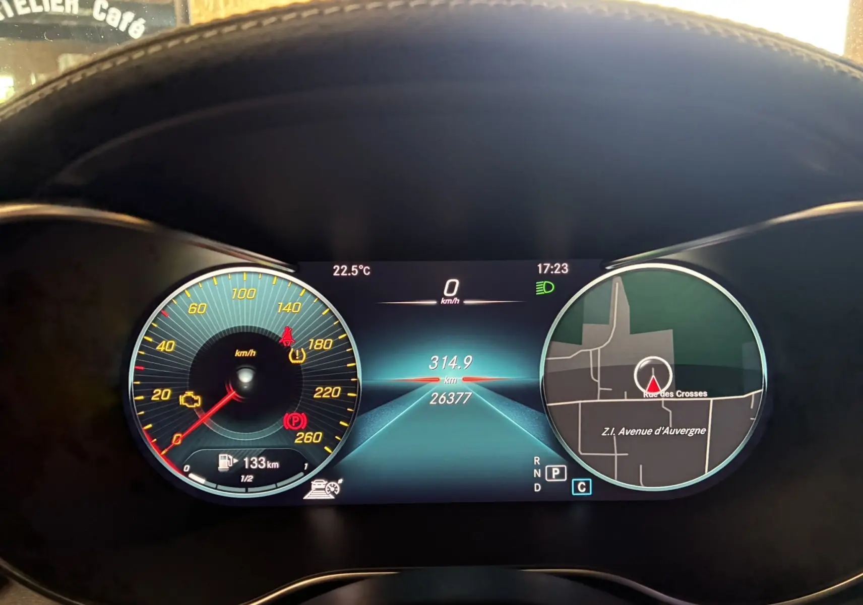 Tableau de bord numérique de Mercedes Classe C Break 220D AMG Line, affichant vitesse, GPS et alertes, vue frontale intérieure.