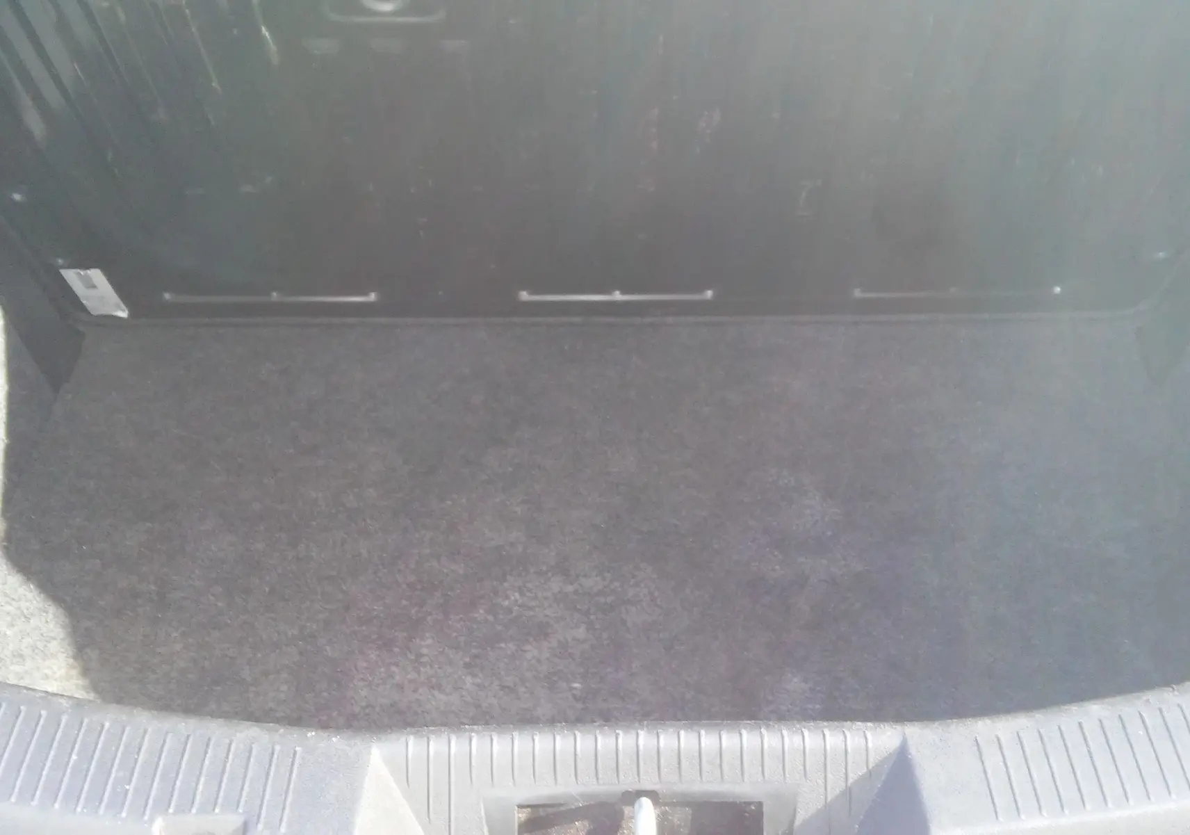 Coffre vide vu de dessus d'une Alfa Romeo MiTo rouge 2010, mettant en valeur son espace de chargement propre et fonctionnel.