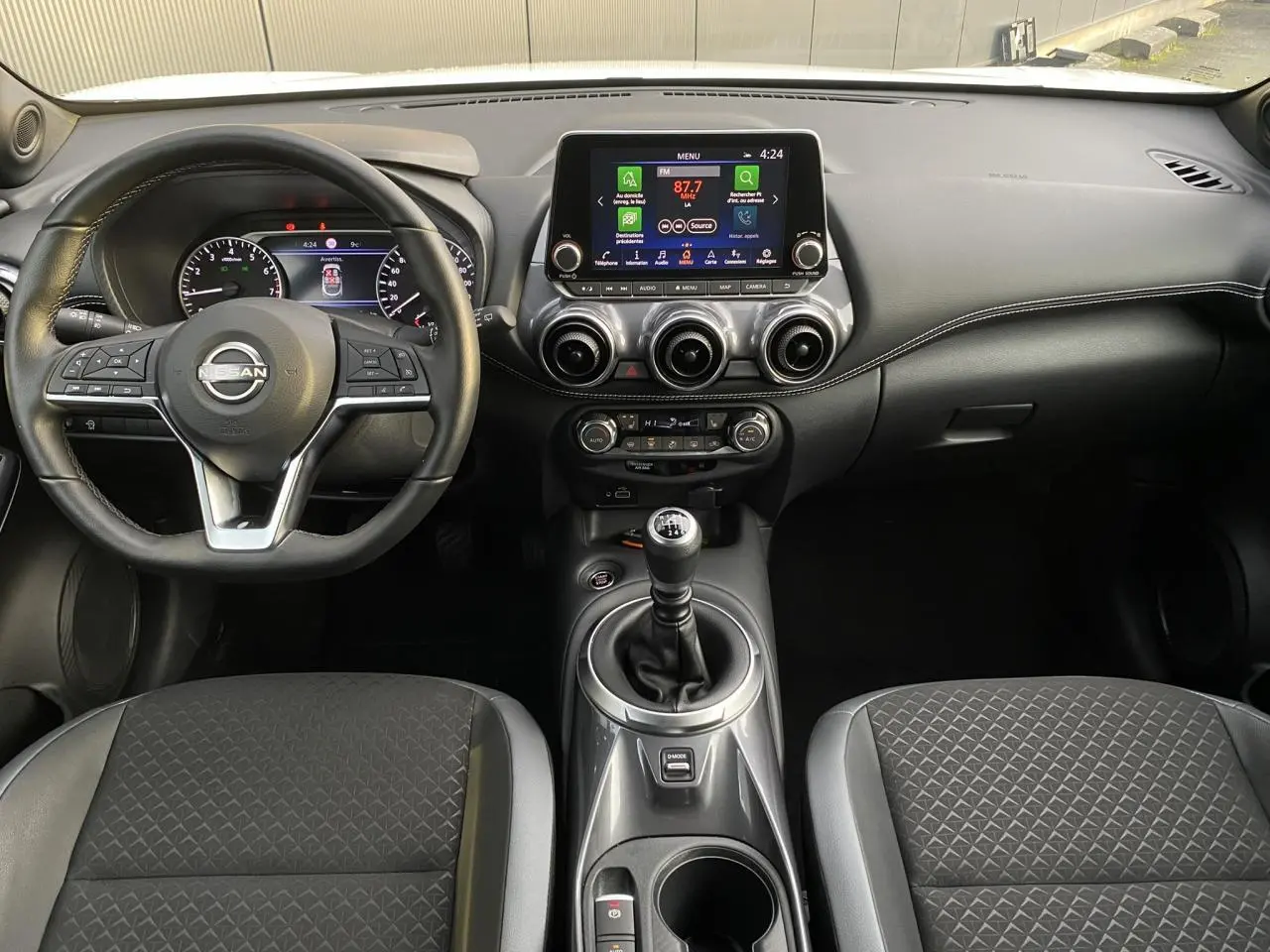 Intérieur du Nissan Juke 2024 DIG-T 114 N-Connecta, vue frontale du tableau de bord avec volant et écran tactile.