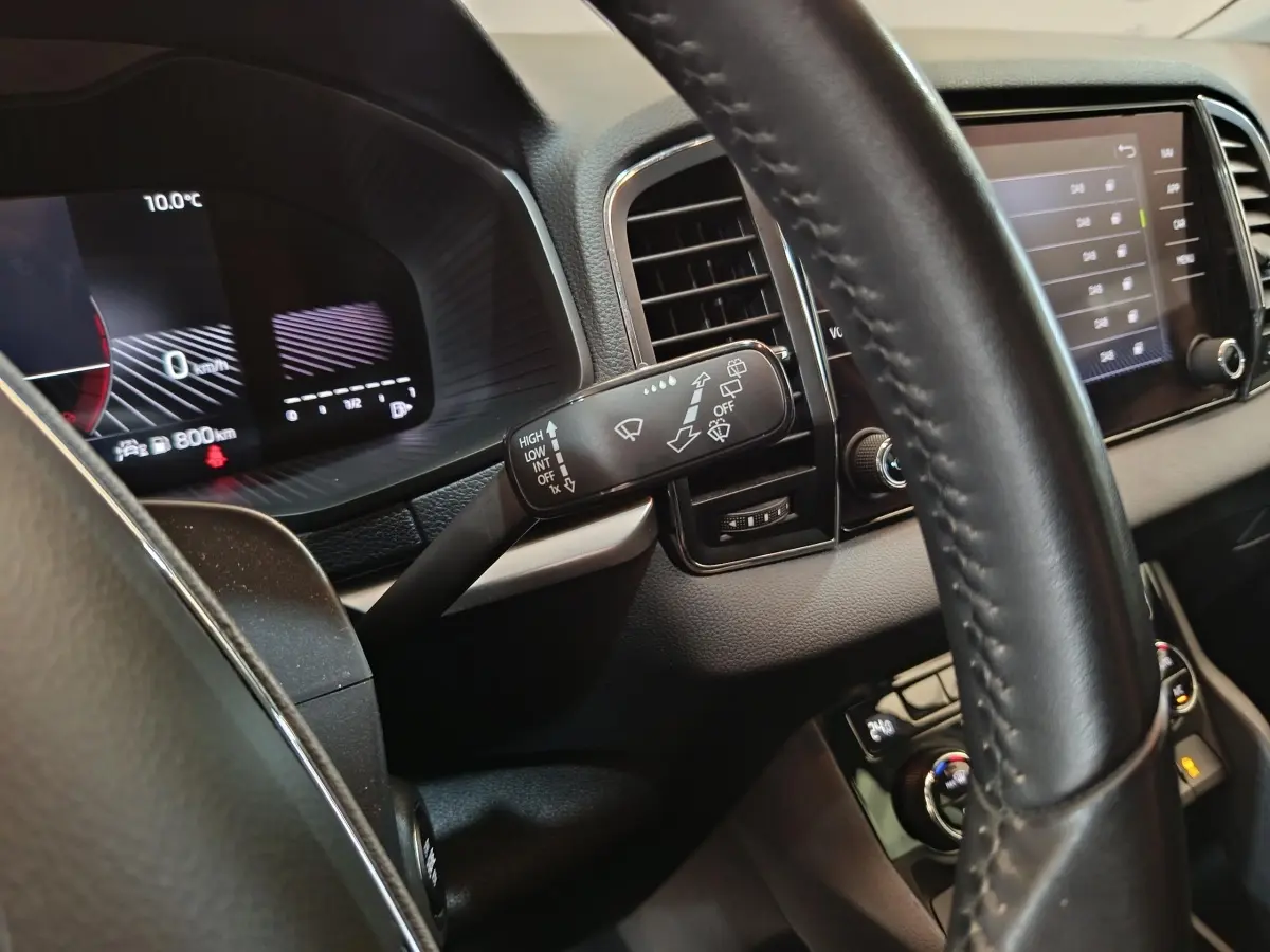 Intérieur noir du Skoda Karoq 2024, vue rapprochée du volant et du tableau de bord numérique avec écran tactile.