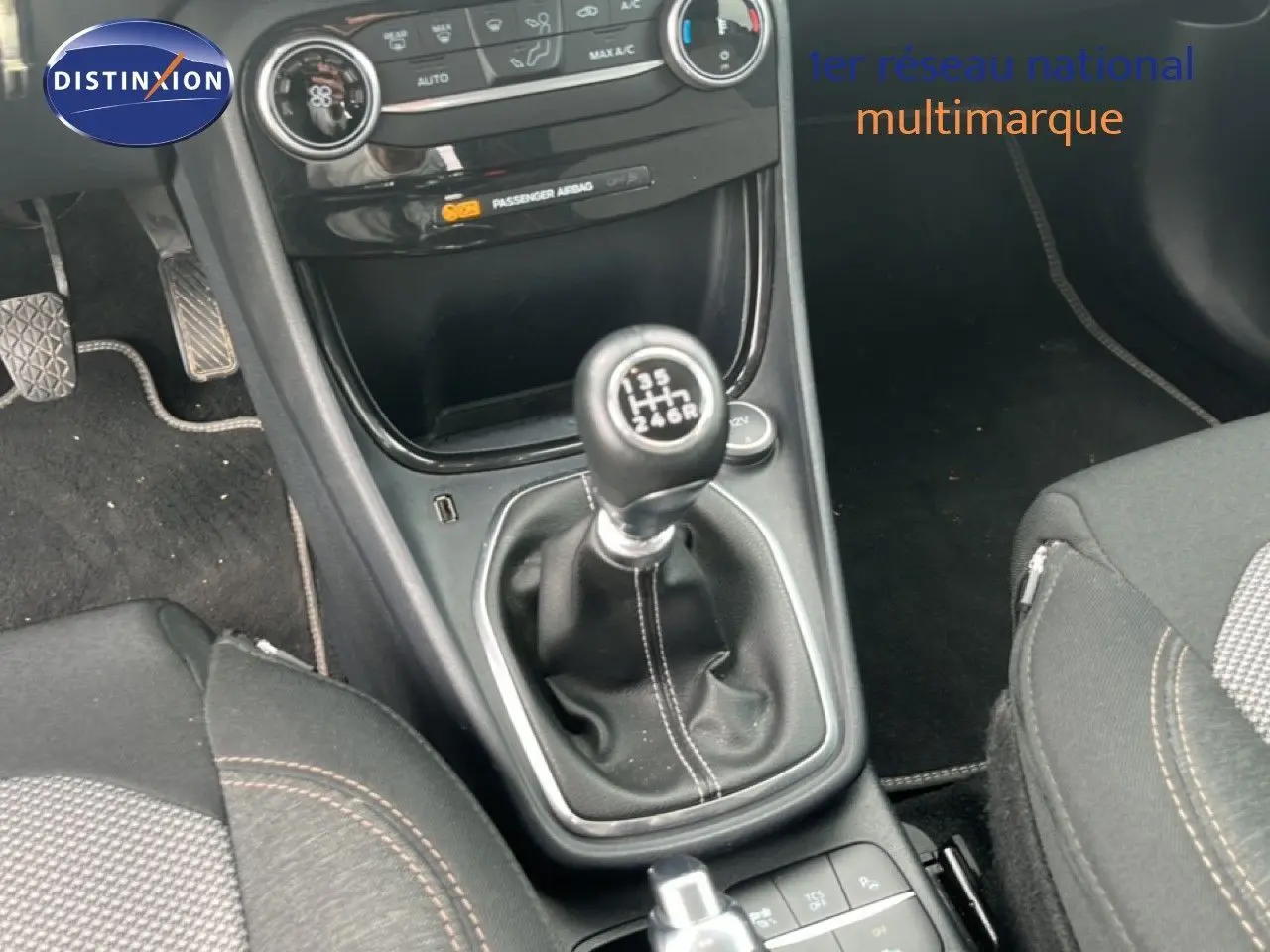 Gros plan sur la console centrale du Ford Puma gris 2021, mettant en valeur le levier de vitesse manuel et les sièges tissu.