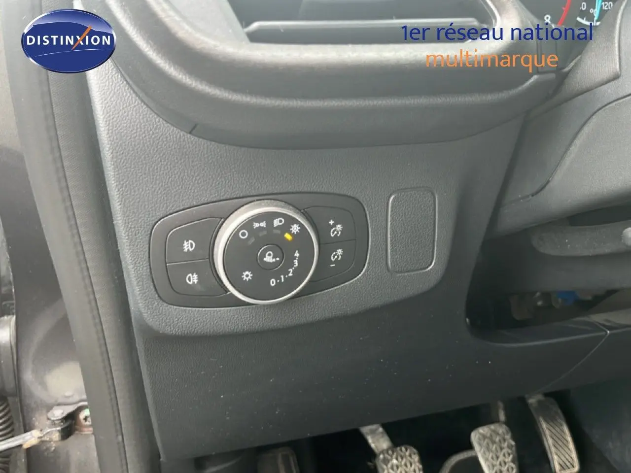 Détail du tableau de bord côté gauche du Ford Puma gris 2021, avec commande des phares et pédales visibles.