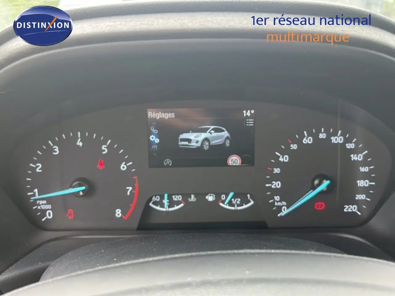 Vue rapprochée du tableau de bord numérique du Ford Puma gris 2021, affichant les compteurs et l'écran central.