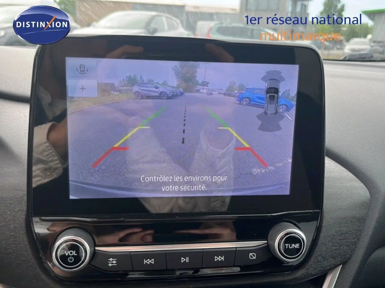 Écran central du Ford Puma gris 2021 montrant la caméra de recul avec guidage coloré en stationnement.