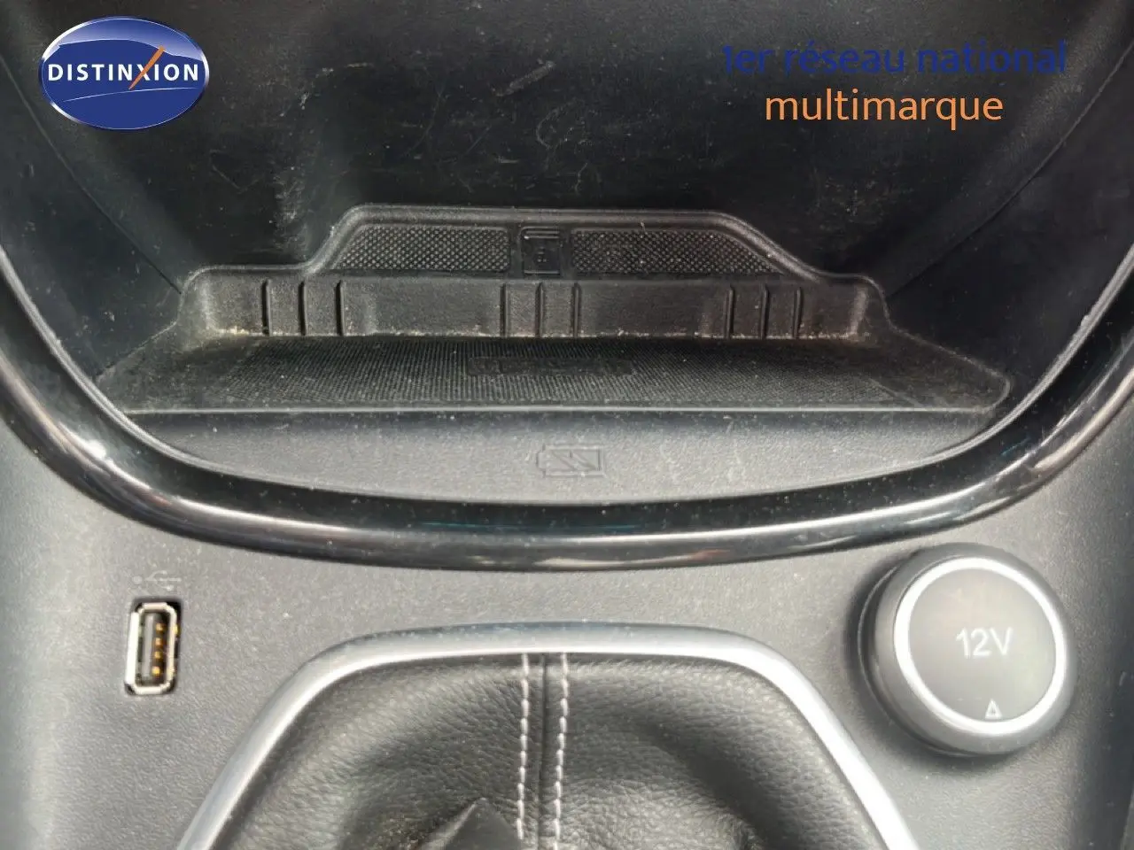 Gros plan sur la console centrale du Ford Puma gris 2021, avec prise USB, prise 12V et espace de rangement.