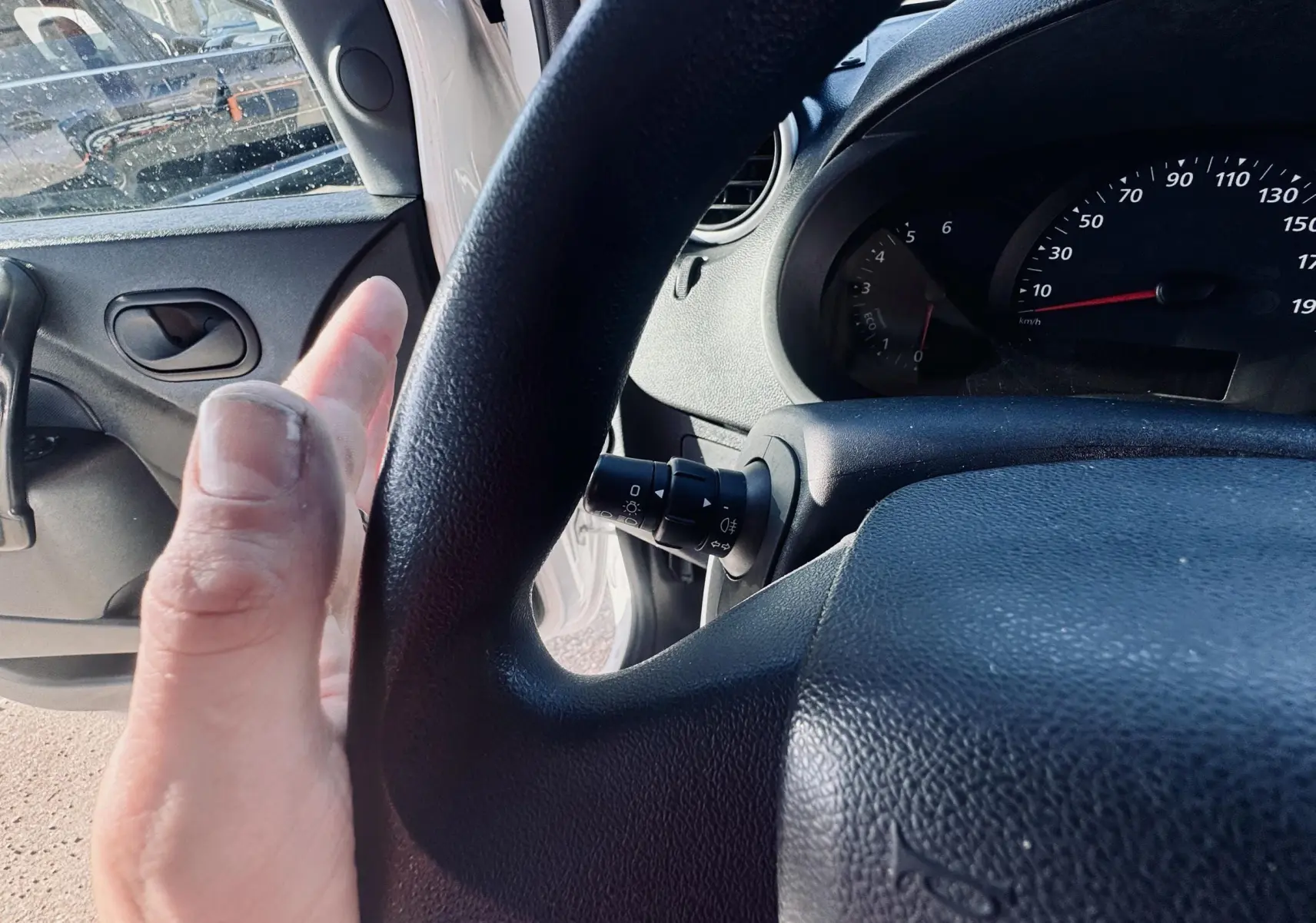 Vue intérieure côté conducteur du Renault Kangoo blanc 2021, avec volant et compteur visibles.