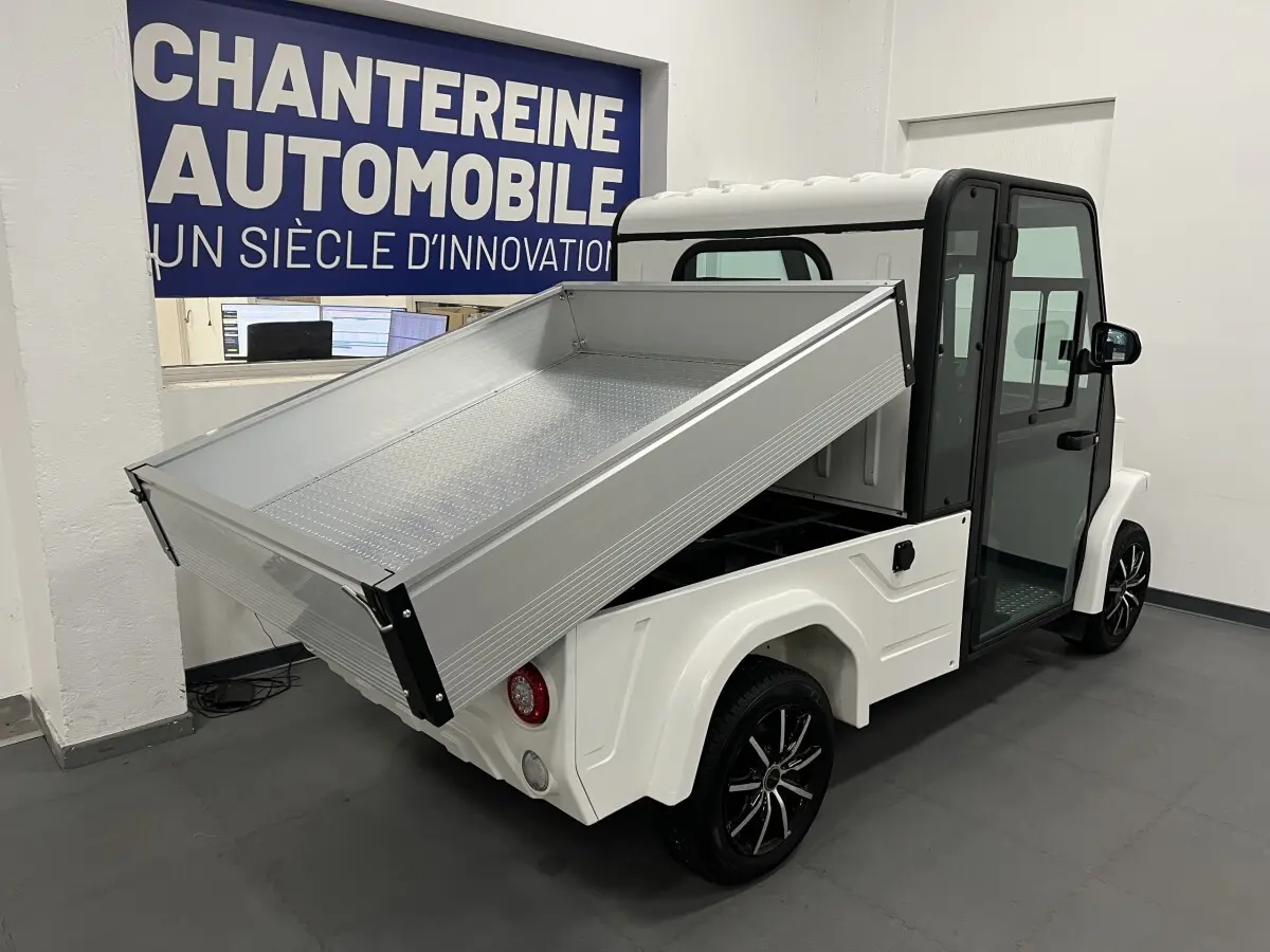 Vue 3/4 arrière droite du pick-up électrique blanc Liberty L7E H2 160 avec kit ridelles relevé et jantes alliage 13 pouces.