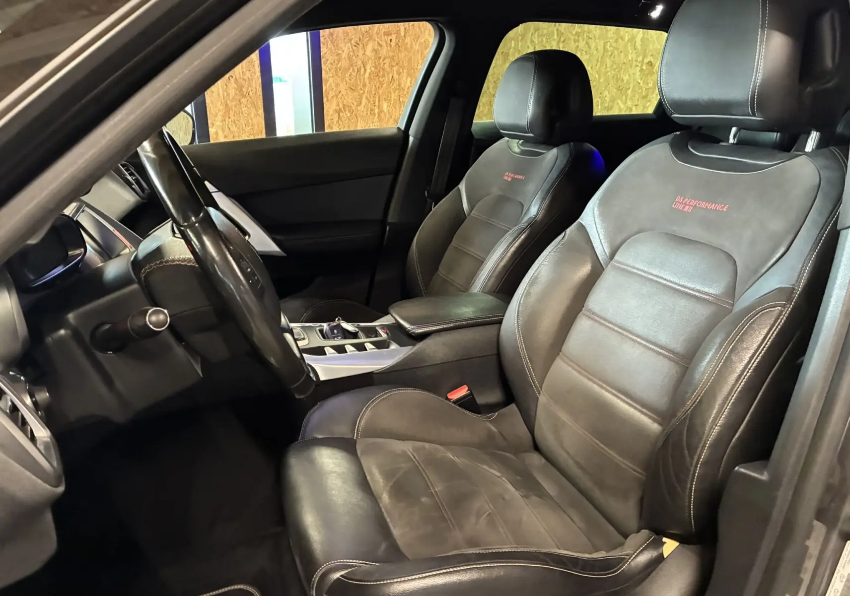 Vue intérieure côté conducteur de la DS5 2018, sièges noirs en cuir avec inscription rouge "DS Performance Line".