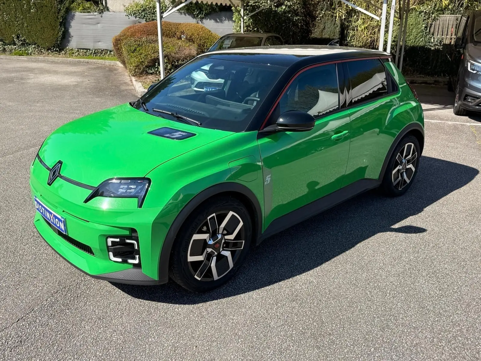 Renault R5 E-Tech électrique 2024 en 3/4 avant droit, vert Pop avec toit noir étoile et jonc rouge alu.