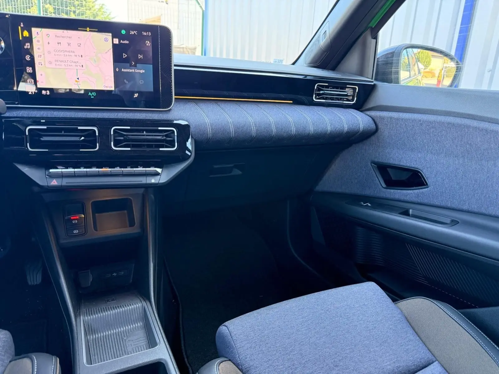 Vue intérieure côté passager de la Renault R5 E-TECH 100% électrique 2024 avec tableau de bord et sellerie textile grise.