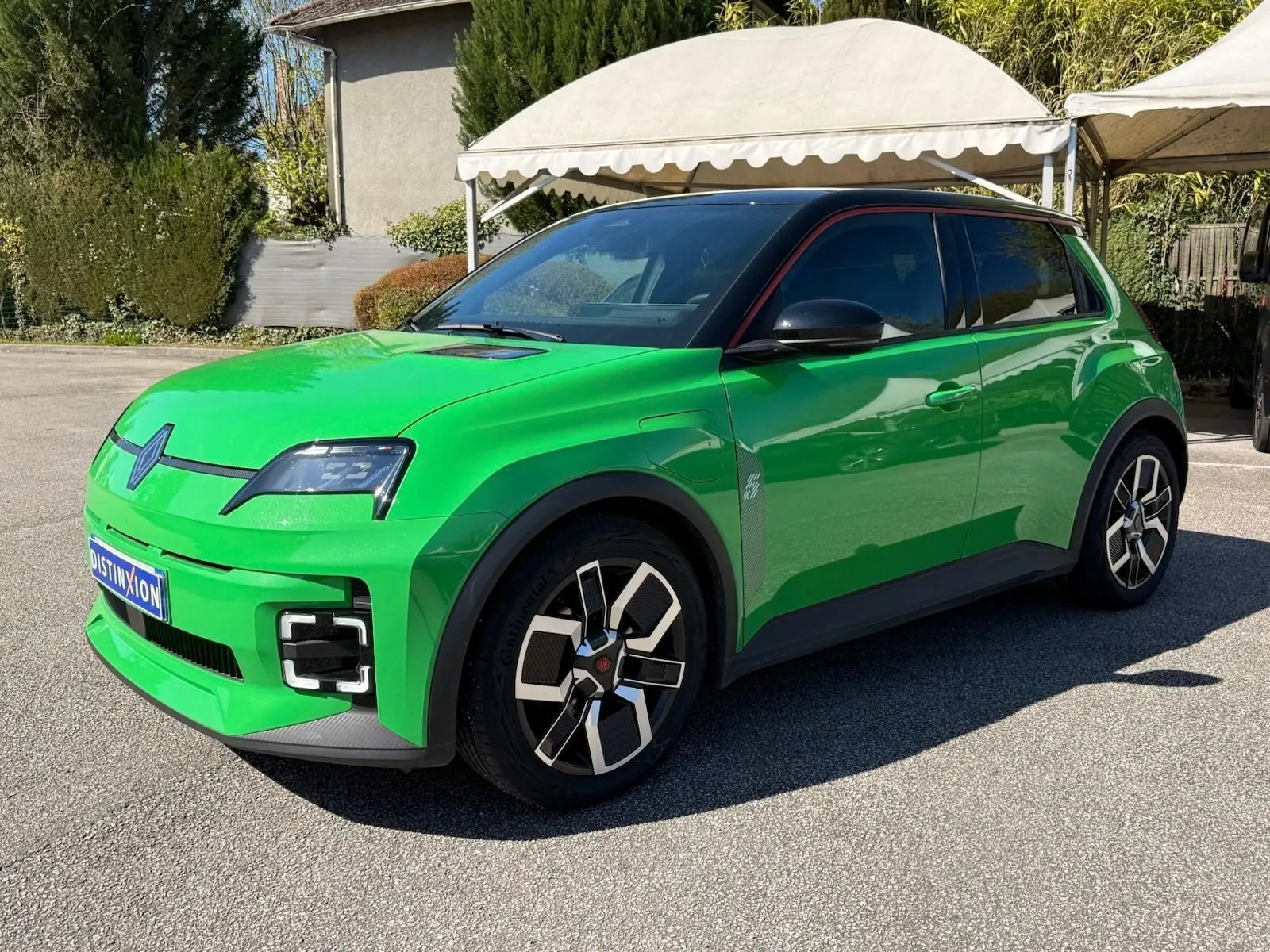 Renault R5 E-Tech électrique 2024 en 3/4 avant, vert Pop avec toit noir étoile et jonc rouge alu visible.