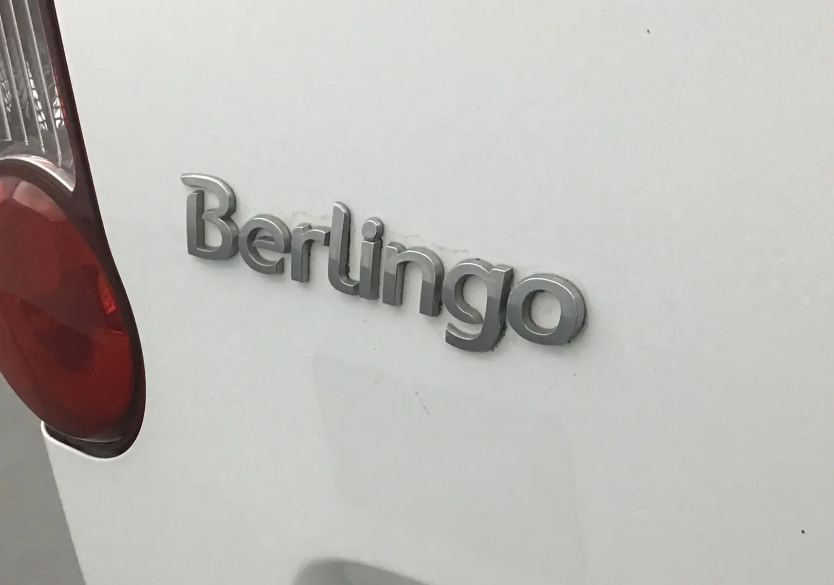 Gros plan sur l'arrière blanc d'un Citroën Berlingo 2018 avec le logo Berlingo et un feu arrière rouge visible.